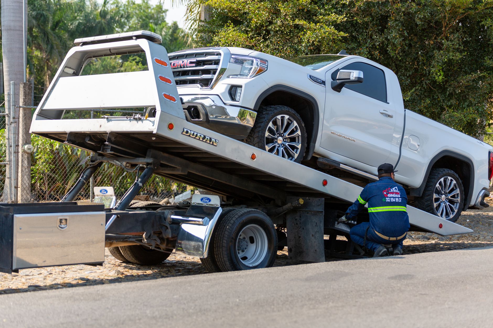 A Snappy Towing operator assisting a driver with a flat tire on the side of a road in Sackville, NS.